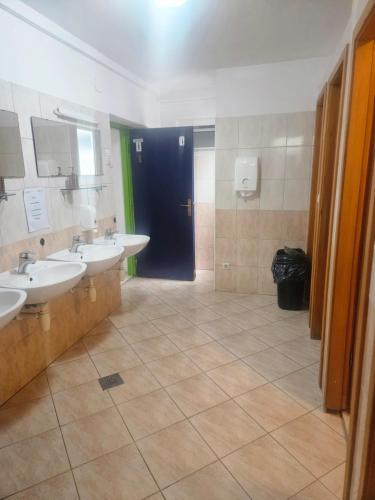 a bathroom with two sinks and a blue door at HI Hostel Dubrovnik in Dubrovnik