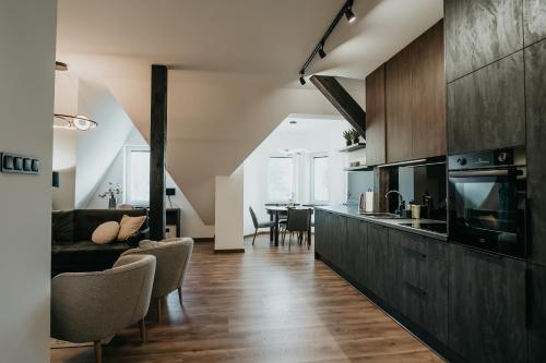 a kitchen and living room with a couch and a table at Castle Lakes - Apartamenty in Grzymalin