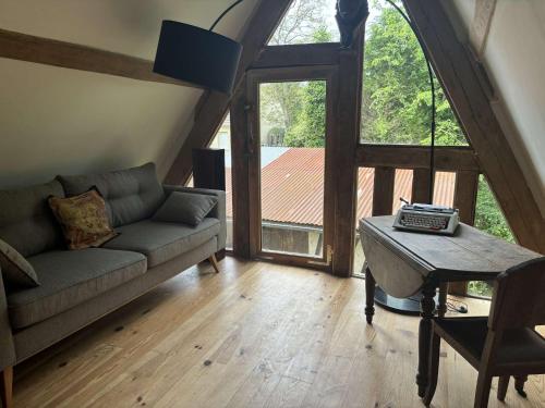 un salon avec un canapé et une table dans l'établissement Chaumière d'écrivain au cœur de la Normandie, à Fiquefleur-Équainville