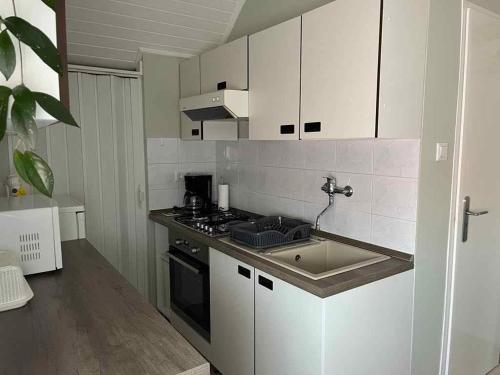 a kitchen with a sink and a stove top oven at Holiday home in Gyenesdias - Balaton 40755 in Gyenesdiás