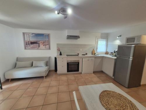 Il comprend une cuisine équipée d'un réfrigérateur et un canapé. dans l'établissement Grand Studio à Deux Pas de la Mer La Ciotat, à La Ciotat