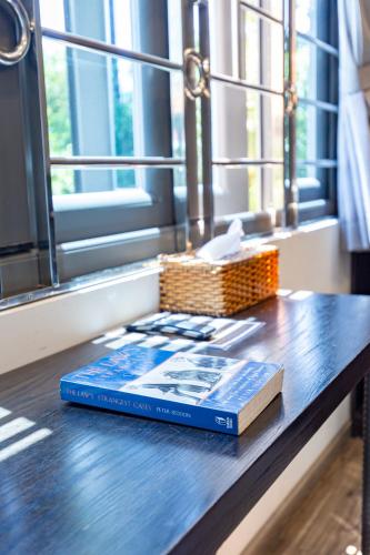 two books sitting on a table next to a window at Brand New Cozy Home in D1 wBalcony in Ho Chi Minh City