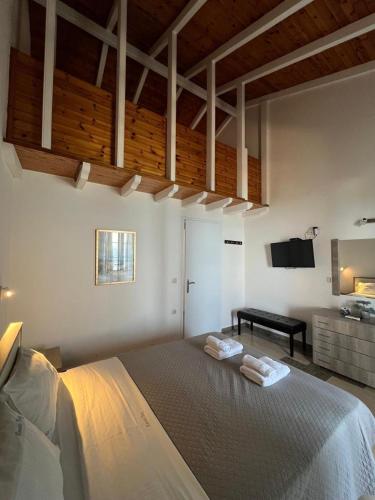 a bedroom with a large bed with two towels on it at Nissaki Bay in Nisakion