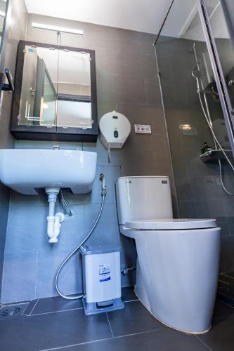 a bathroom with a toilet and a sink and a mirror at Brand New Cozy Home in D1 wBalcony in Ho Chi Minh City