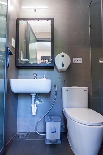 a bathroom with a sink and a toilet and a mirror at Brand New Cozy Home in D1 wBalcony in Ho Chi Minh City