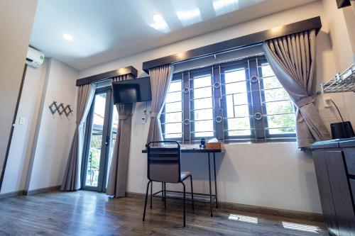 a kitchen with a table and a chair in front of a window at Brand New Cozy Home in D1 wBalcony in Ho Chi Minh City