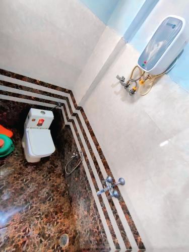 a bathroom with a toilet and a sink in a room at Rudra Guest House verul in Ellora