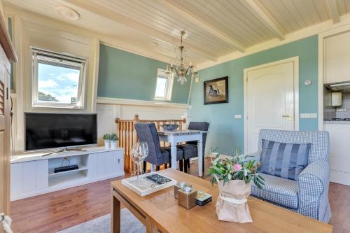 a living room with a television and a table at Appartement RoMi in Koedijk