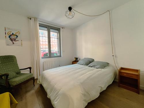 a bedroom with a white bed and a chair at Loft Évasion aux Portes de Paris in Bagnolet