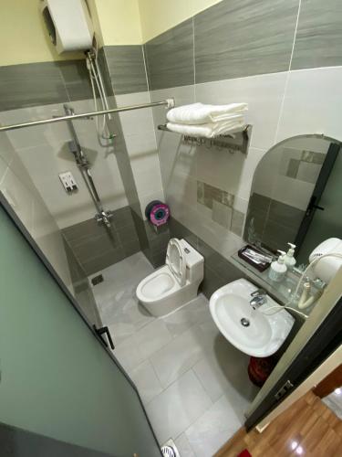 a bathroom with a toilet and a sink at Winston Hotel Riverside in Ho Chi Minh City