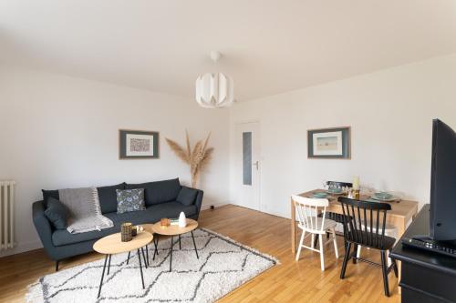 un salon avec un canapé et une table dans l'établissement Le Montaigne - appt proche de la gare, à Rennes
