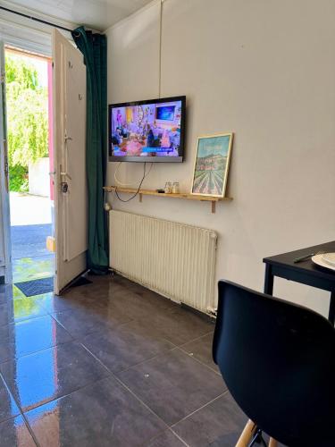 Cette chambre comprend une télévision, une table et une chaise. dans l'établissement Ancienne chambre d hôtel, à Sainte-Savine