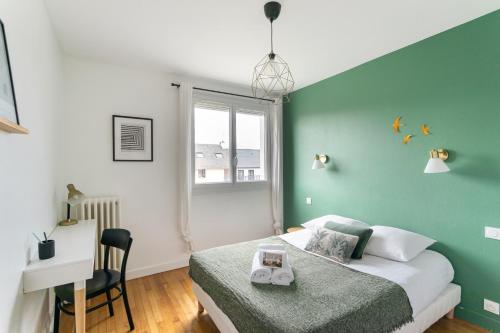 - une chambre avec un mur vert, un lit et un bureau dans l'établissement Le Montaigne - appt proche de la gare, à Rennes