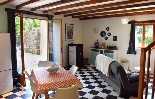 un salon avec une table et une cuisine dans l'établissement Charmant gîte breton authentique, à Séglien