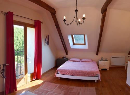 une chambre avec un lit et une grande fenêtre dans l'établissement Charmant gîte breton authentique, à Séglien