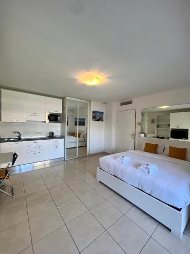 une grande chambre avec un grand lit et une cuisine dans l'établissement Studio Palais de la Méditerranée, à Nice