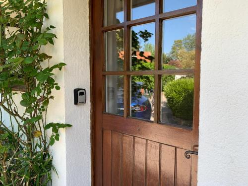 une porte en bois avec une fenêtre sur une maison dans l'établissement Au jet de pierre, à Saint-Inglevert