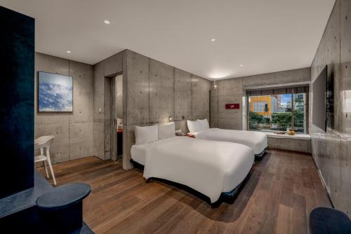 two white beds in a room with wooden floors at Oday Stay Boutique Hotel Da Nang - 2 Minutes to Dragon Bridge in Da Nang