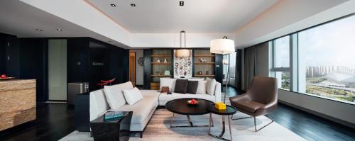 a living room with a white couch and a table at New World Shenyang Hotel in Shenyang