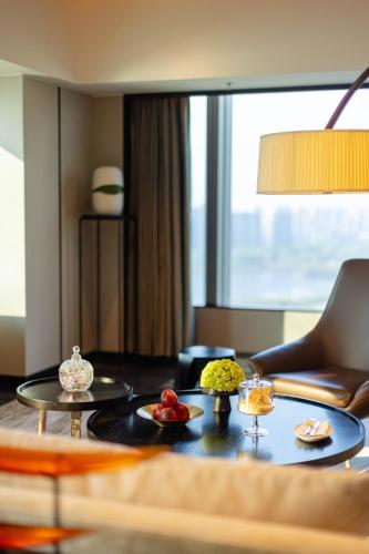 a living room with a table with fruit on it at New World Shenyang Hotel in Shenyang