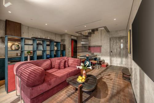 a living room with a red couch and a table at Oday Stay Boutique Hotel Da Nang - 2 Minutes to Dragon Bridge in Da Nang