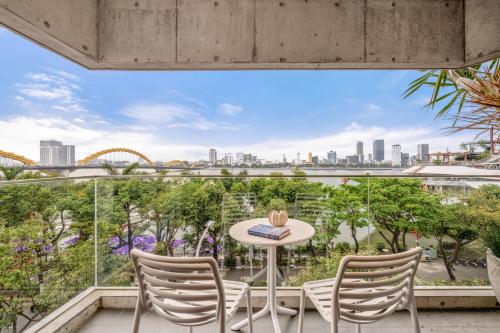 a balcony with a table and chairs and a view of the city at Oday Stay Boutique Hotel Da Nang - 2 Minutes to Dragon Bridge in Da Nang