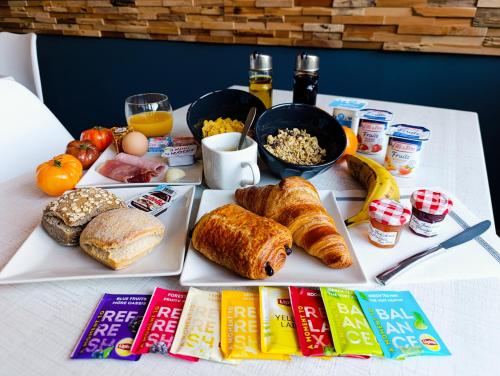 a table with breakfast foods and drinks on it at Hotel Le Majestic Canet plage in Canet-en-Roussillon