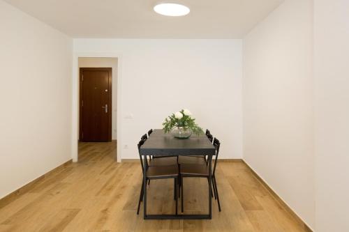 サロウにあるApartamento con Piscina a 100 M de la playaのダイニングテーブル(植物付)