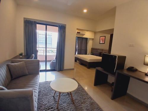 a living room with a couch and a bed at Housr Wakad Pune, Hinjawadi Road in Pune