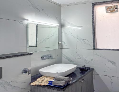 a white bathroom with a sink and a mirror at Housr Wakad Pune, Hinjawadi Road in Pune
