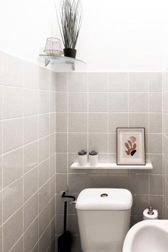 a bathroom with a toilet and two plants on a shelf at 4p-home at best Spot in town near poppodium 013 in Tilburg