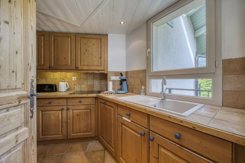 une cuisine avec un évier et une fenêtre dans l'établissement Roseaux du chateau, à Duingt