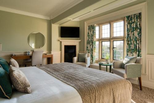 a bedroom with a large bed and a living room at Fanhams Hall, Exclusive Collection in Ware