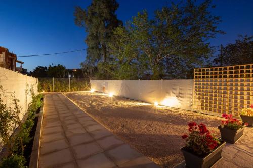 a driveway with lights on a fence at night at AGGELLE Villa in Potamós