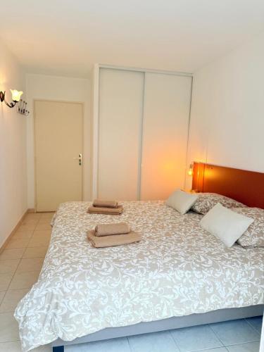 a bedroom with a large bed with two towels on it at Les 3 Îles Appartement 2 pièces climatisé à 50 m des plages in Antibes