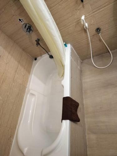 a bath tub in a bathroom with a shower at Shenbaga Hotel And Convention Centre in Puducherry