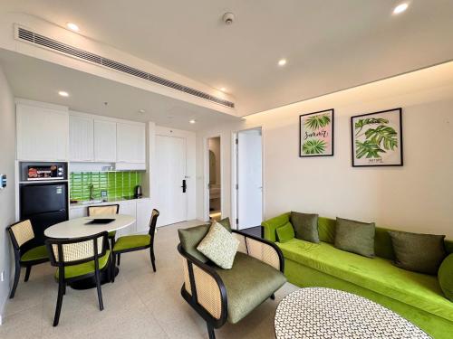 a living room with a green couch and a table at Sunset town Phú Quốc in Phu Quoc