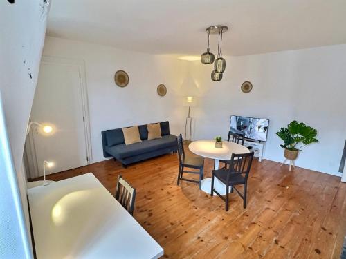 un salon avec une table et un canapé bleu dans l'établissement WonderHost, une entrée Historique sur la Ville, à Pau