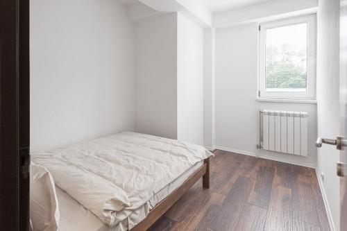 biała sypialnia z łóżkiem i oknem w obiekcie Flat N 5 w mieście Skopje
