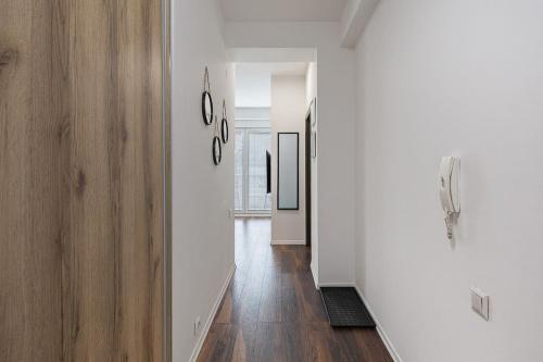 pusty korytarz z białymi ścianami i drewnianą podłogą w obiekcie Flat N 5 w mieście Skopje