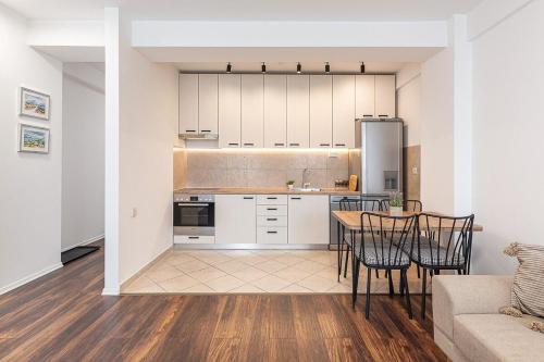una cucina e una sala da pranzo con tavolo e sedie di Flat N 5 a Skopje