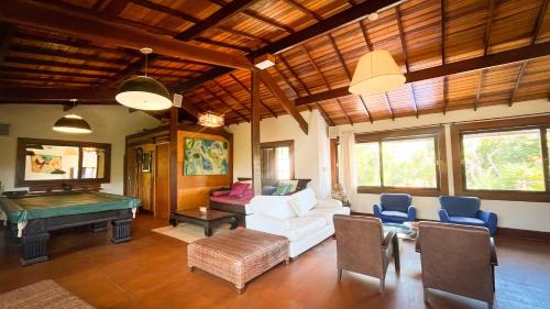 a living room with a pool table and a white couch at 3 Palmeiras Guest Lounge in Miguel Pereira
