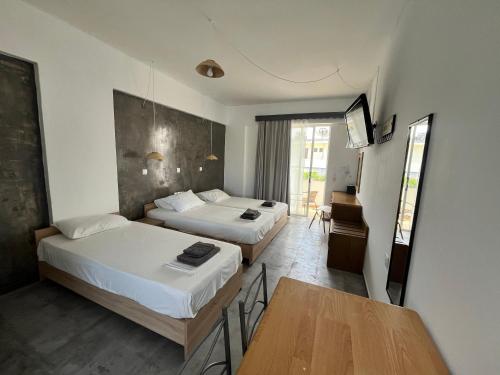 pokój hotelowy z 2 łóżkami i stołem w obiekcie Family House Faliraki Studios Apartments w mieście Faliraki