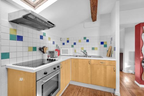 une cuisine avec un évier et une cuisinière dans l'établissement Spacious and bright in the historic center, à Toulouse