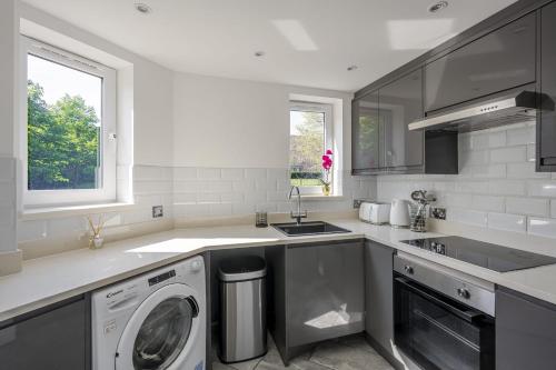 a kitchen with a washing machine and a sink at Luxurious 2 Bed with Free Parking near Chelmsford City in Chelmsford