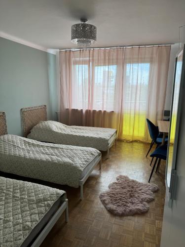 a bedroom with three beds and a rug on the floor at Mieszkaj u Marty stale na Stałym in Jaworzno