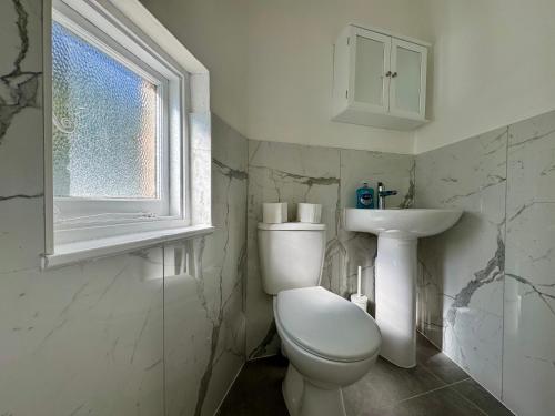 a white bathroom with a toilet and a sink at Oxford Street Apartments in Southampton