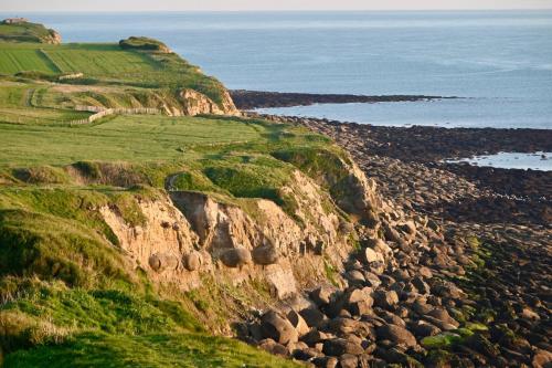 a rocky mountain with the ocean in the background at La Naturelle Duplex 90 in Wimereux