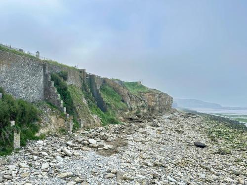 a rocky beach next to a large stone wall at La Naturelle Duplex 90 in Wimereux