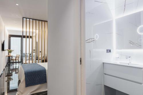 eine weiße Küche mit einer Spüle und einer Theke in der Unterkunft Un acogedor complejo compuesto de 5 apartamentos in Barbate